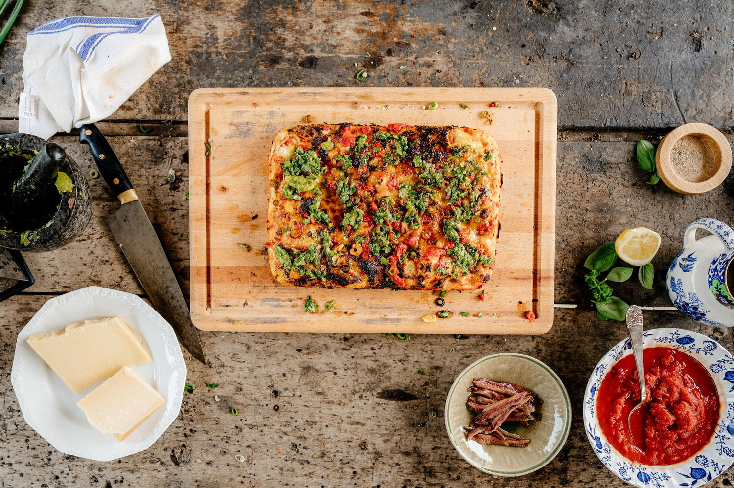 Green Garlic Marinara Pizza Displayed on a Cutting Board
