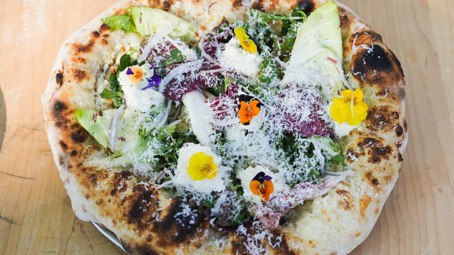 Salad Pizza cooked and presented on wood cutting board