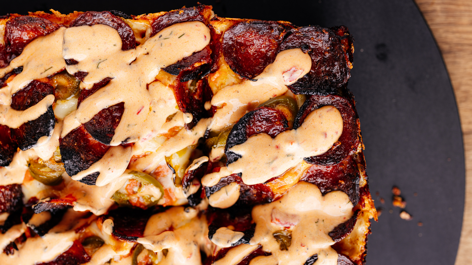 Vodka Pepperoni Detroit Pizza topped with Spicy Ranch in diagonal pattern