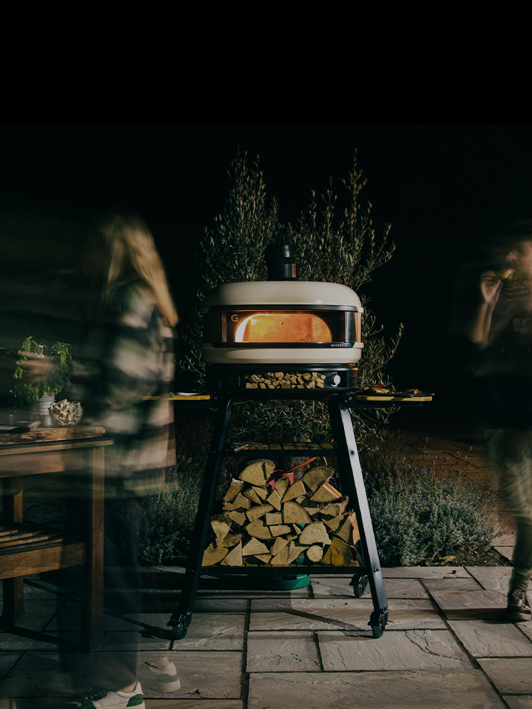 Pizza party at night with lit pizza oven