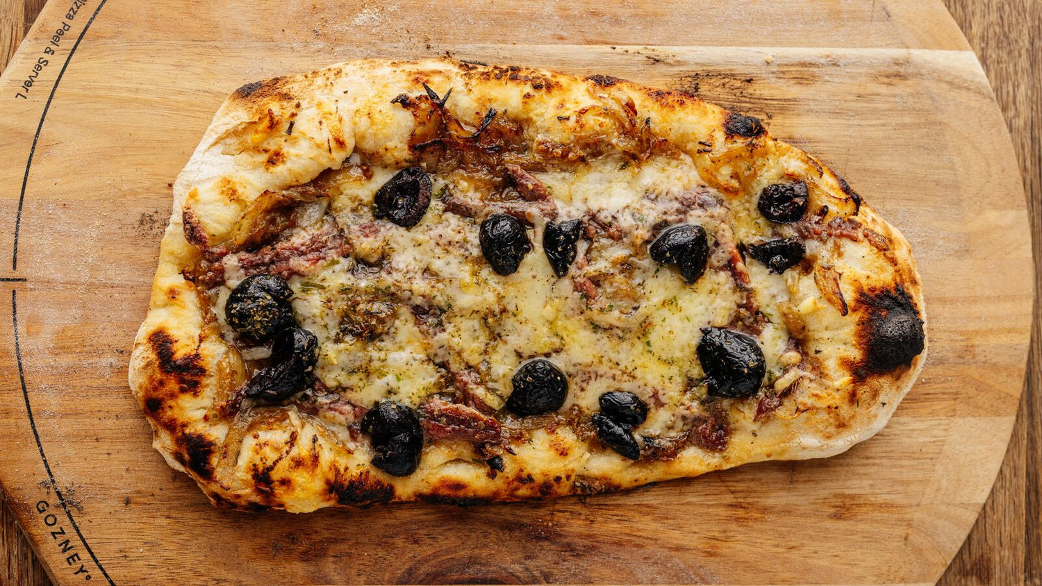 Pissaladière on a wooden cutting board recipe poster image